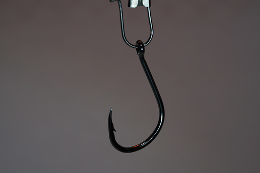 Fishing hook on a dark background. Close-up. Selective focus.