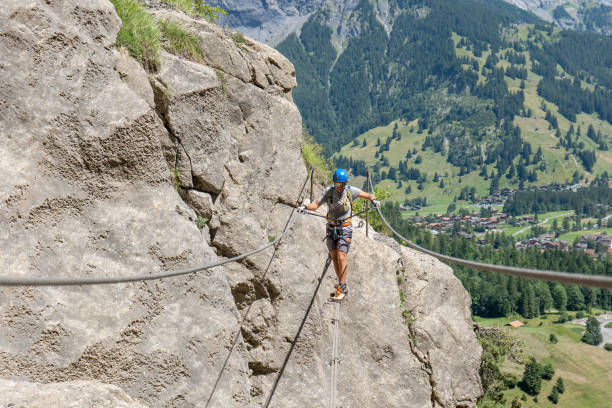 istock Man on Via Ferrata crossing on a suspension bridge 1495646162