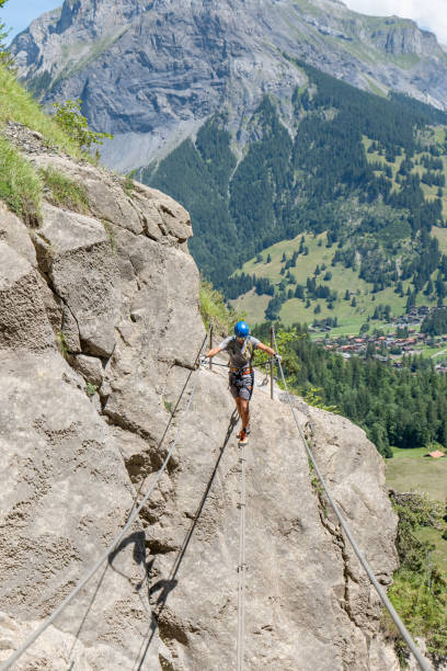 istock Man on Via Ferrata crossing on a suspension bridge 1495646231