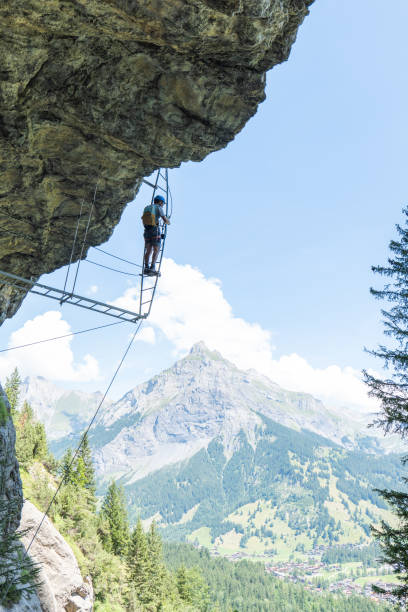 istock Low angle view, man on Via Ferrata climbing up a ladder, success concept 1495646702