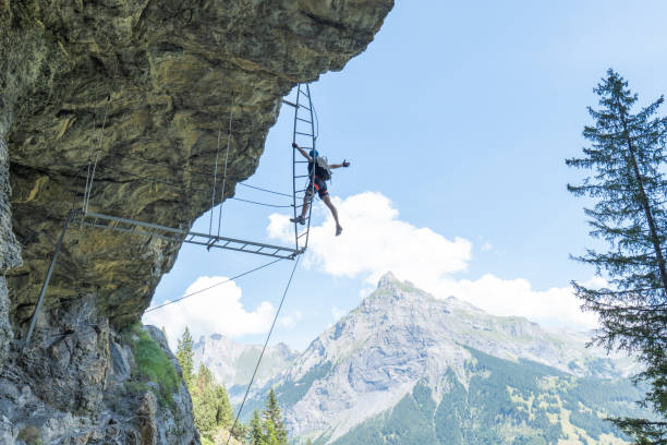istock Low angle view, man on Via Ferrata climbing up a ladder, success concept 1495646810
