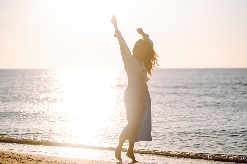 Beautiful woman  walking at a beach at sunset. Summer time.