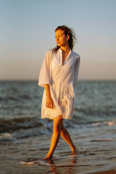 istock Beautiful woman  walking at a beach at sunset. 1495648091