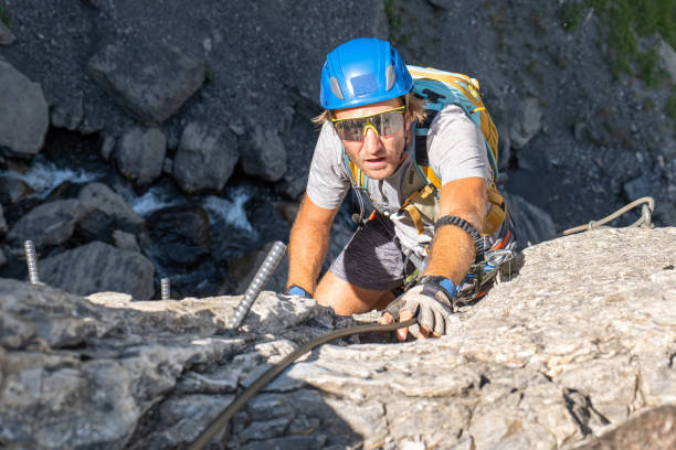 istock Young man on Via Ferrata climbing up a ladder on a rock face 1495648601