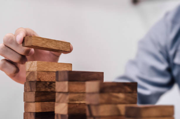 istock Man hand arranging wood block stackingBusiness planning development 1495649772