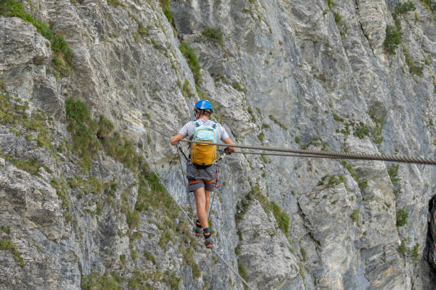 istock Man on Via Ferrata crossing on a suspension bridge 1495649883