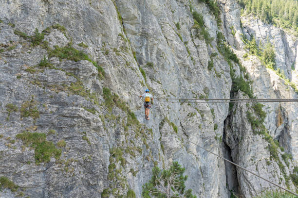 istock Man on Via Ferrata crossing on a suspension bridge 1495650323