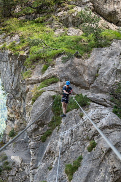 istock Man on Via Ferrata crossing on a suspension bridge 1495650416