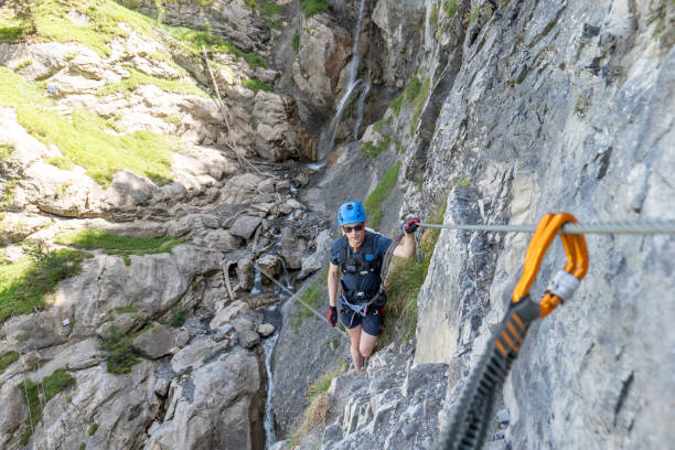 istock Young man on Via Ferrata climbing up a ladder on a rock face 1495651316