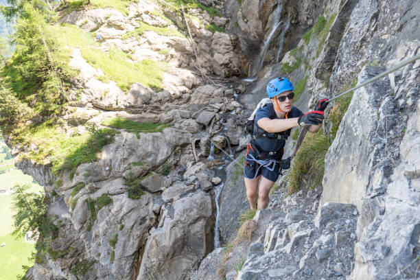 istock Young man on Via Ferrata climbing up a ladder on a rock face 1495651346