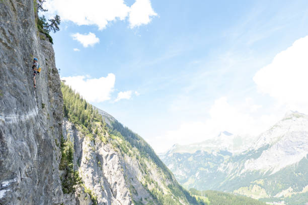 istock Young man on Via Ferrata climbing up a ladder on a rock face 1495651361