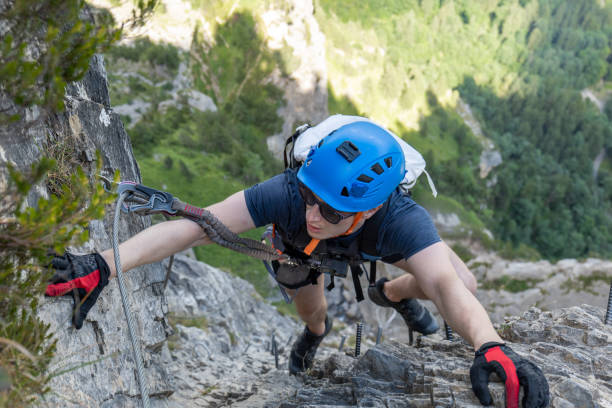 istock Young man on Via Ferrata climbing up a ladder on a rock face 1495651595