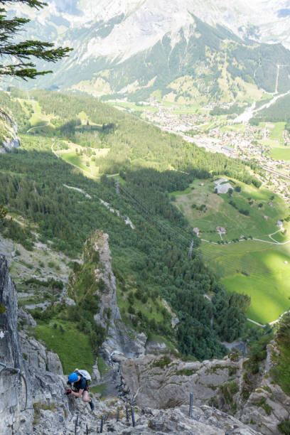 istock Young man on Via Ferrata climbing up a ladder on a rock face 1495651611