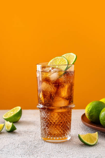 istock Fresh made Cuba Libre with rum, cola and lime on color background. Cold long drink 1495655595