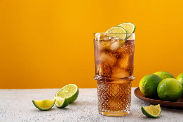 istock Fresh made Cuba Libre with rum, cola and lime on color background. Cold long drink 1495655613