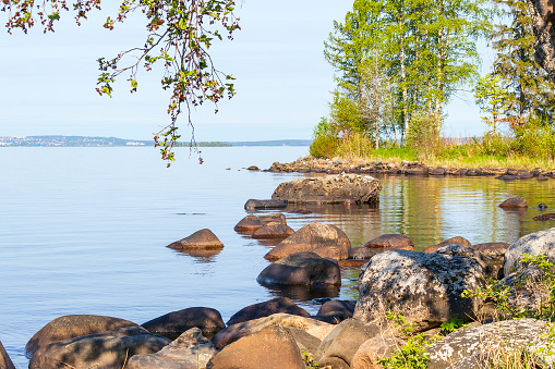 Landscape of Lake Onega in Karelia with large stones and boulders along the shore.
