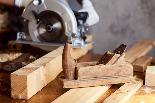 istock Skilled female carpenter using a circular saw. Woman worker in the carpenter workroom renovation. Small business concept 1495664097