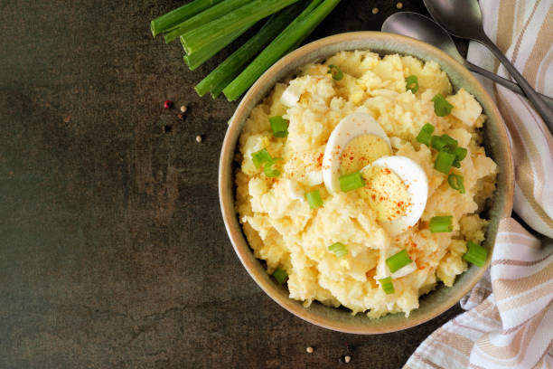 Traditional potato salad, top down table scene on dark stone
