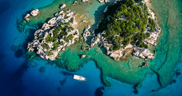 Kekova, also named Caravola, is a small Turkish island near Demre (Demre is the Lycian town of Myra) district of Antalya province which faces the villages of Kaleköy (ancient Simena) and Üçağız (ancient Teimioussa). Kekova has an area of 4.5 km2 (2 sq mi) and is uninhabited. simena - antigua ciudad licia sumergida isla kekova ruinas de arquitectura antigua, vista aérea de la ciudad hundida histórica hundida, lugar para explorar submarino, submarino limpio, punto de descubrimiento para buceadores, un barco para un crucero en