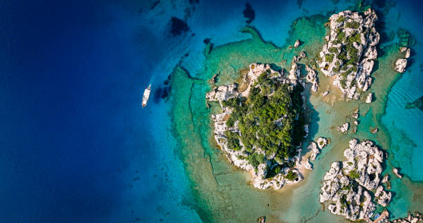 Kekova, also named Caravola, is a small Turkish island near Demre (Demre is the Lycian town of Myra) district of Antalya province which faces the villages of Kaleköy (ancient Simena) and Üçağız (ancient Teimioussa). Kekova has an area of 4.5 km2 (2 sq mi) and is uninhabited. simena - antigua ciudad licia sumergida isla kekova ruinas de arquitectura antigua, vista aérea de la ciudad hundida histórica hundida, lugar para explorar submarino, submarino limpio, punto de descubrimiento para buceadores, un barco para un crucero en