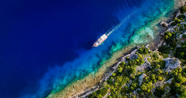 Kekova, also named Caravola, is a small Turkish island near Demre (Demre is the Lycian town of Myra) district of Antalya province which faces the villages of Kaleköy (ancient Simena) and Üçağız (ancient Teimioussa). Kekova has an area of 4.5 km2 (2 sq mi) and is uninhabited. simena - antigua ciudad licia sumergida isla kekova ruinas de arquitectura antigua, vista aérea de la ciudad hundida histórica hundida, lugar para explorar submarino, submarino limpio, punto de descubrimiento para buceadores, un barco para un crucero en