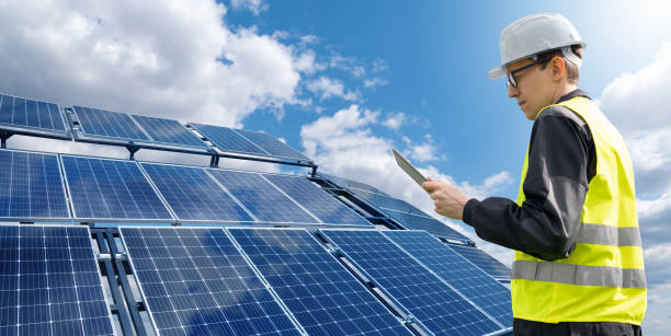 istock Engineer with tablet computer on a background of mobile solar power station 1495681021