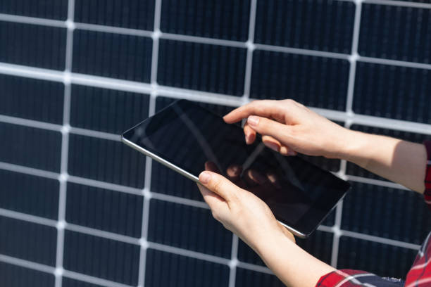 istock Hands with tablet computer on a background of solar panels 1495683819