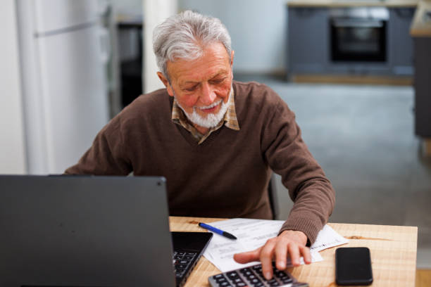 istock The senior man is working from home while calculating finances with a calculator. 1495684297