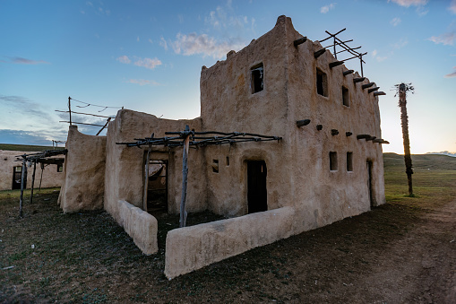 Abandoned oriental village. Ruined houses with straw roofs.