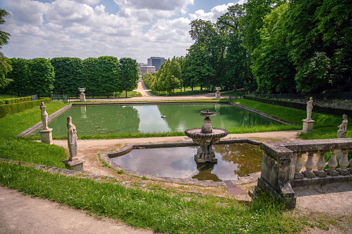 Amazing view in National Domain of Saint-Cloud  with pond (fish) and statue and topiary trees