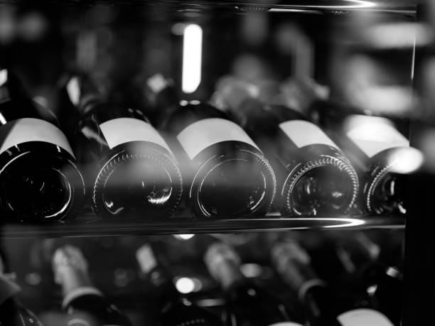 foto em preto e branco de garrafas de vinho no armazenamento de vinho. - food and drink industry fotos - fotografias e filmes do acervo
