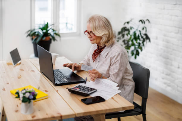 istock A senior woman is working at home while making plans for online shopping. 1495685955