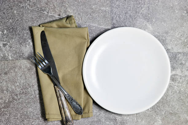 istock Festive fashion table setting. empty white plate with knife and fork, napkin. The distribution of guests in places at the festive table 1495687360