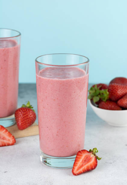 istock Strawberry smoothie or milkshake with berries on a blue background. Summer beverages. 1495690634