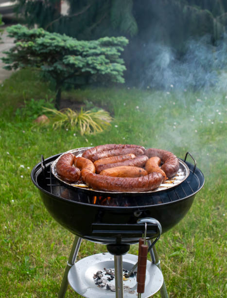 pieces of meat and sausages on fired barbeque grill
