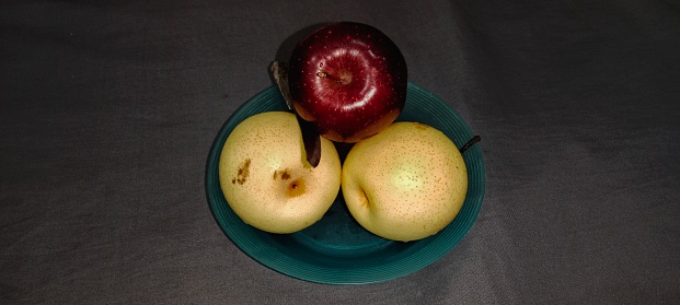 Fresh Pear Fruits in a Bowl on the Kitchen's Wooden Table in Natural condition. Appearing the drops on the fruits.