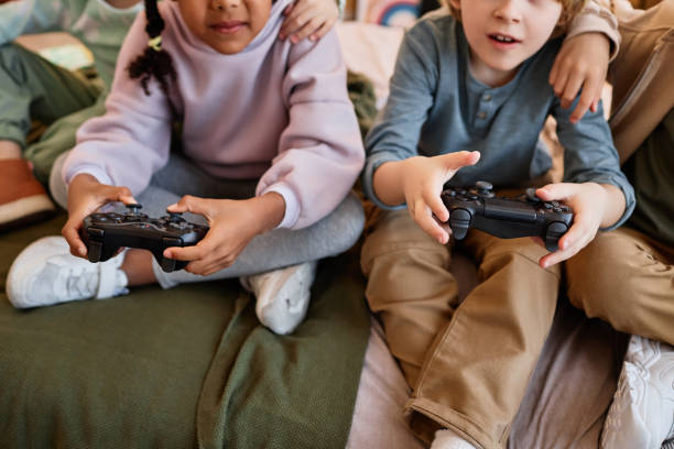 istock Closeup of children playing videogames and holding controllers 1495695079
