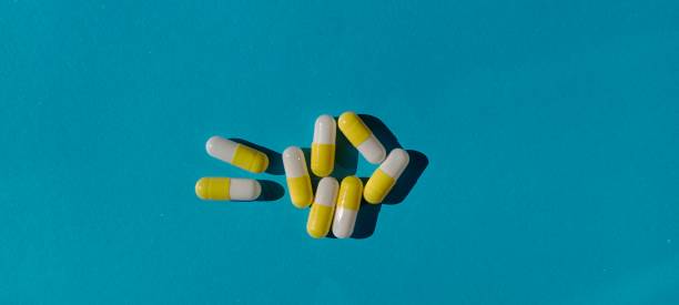 istock capsule pills with yellow and white colors on a blue background 1495696152