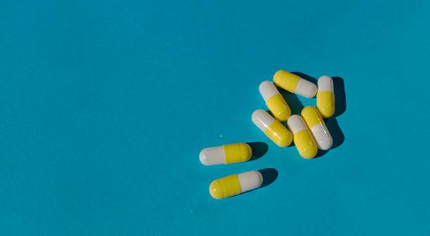 istock capsule pills with yellow and white colors on a blue background 1495696168