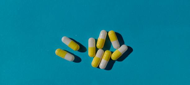 istock capsule pills with yellow and white colors on a blue background 1495696186