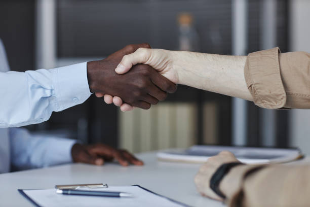 istock Side view senior candidate shaking hands with recruiter at job interview 1495696940