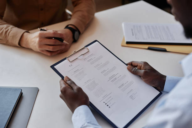 istock Unrecognizable HR recruiter reading CV during job interview 1495696957