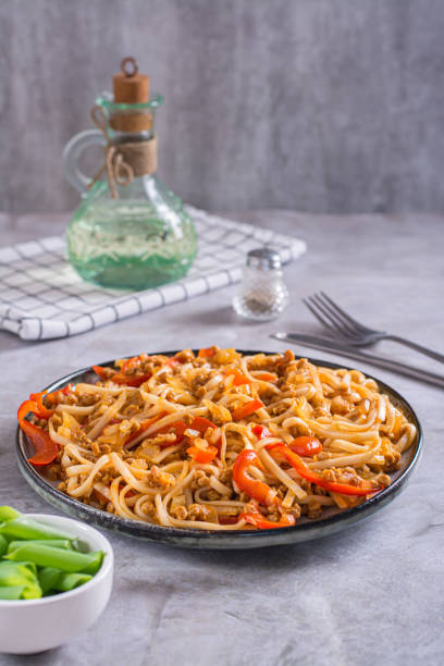 istock Udon noodles with soy meat and vegetables on a plate on the table vertical view 1495697231