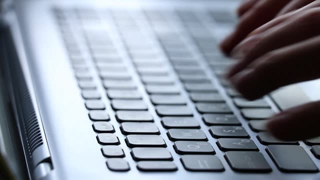 girl typing on laptop keyboard at home