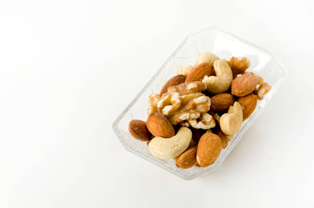 mix of nuts in a Square glass bowl on a white background.