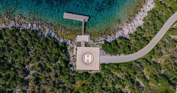 aerial view of helipad and piers on the seashore, pier and airstrip in the turquoise sea, private helipad