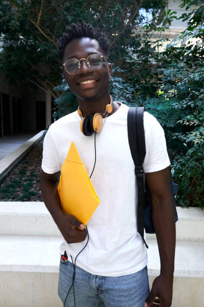 istock Cheerful African student looking camera confident while standing at school patio. 1495706318