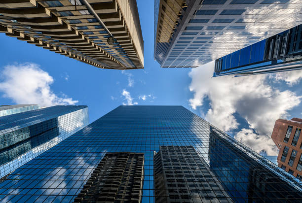 istock Looking up at skyscrapers with clouds and buildings reflected in windows 1495709938