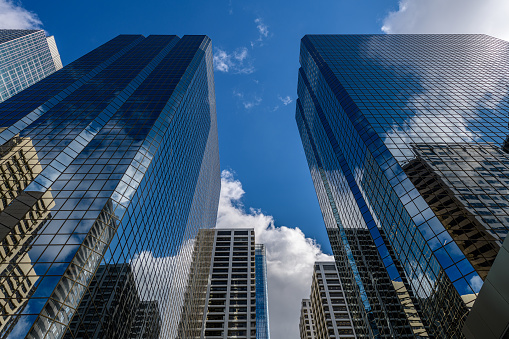 Glass Skyscrapers with clouds and buildings reflected in windows