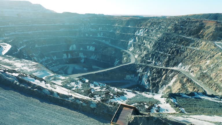 A truck with ore is moving along the open-pit slopes